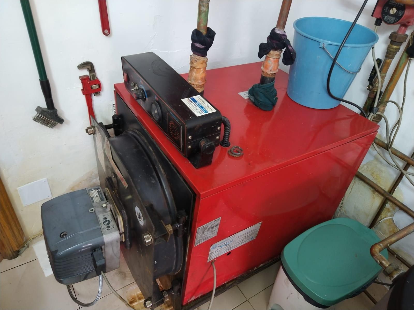 Una caldera roja con un cubo azul encima