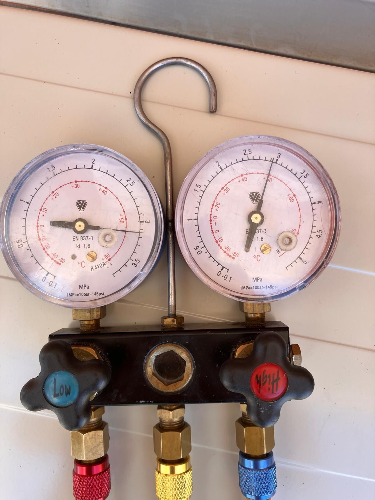 Un par de medidores colgados en un gancho con uno que dice r32 en él